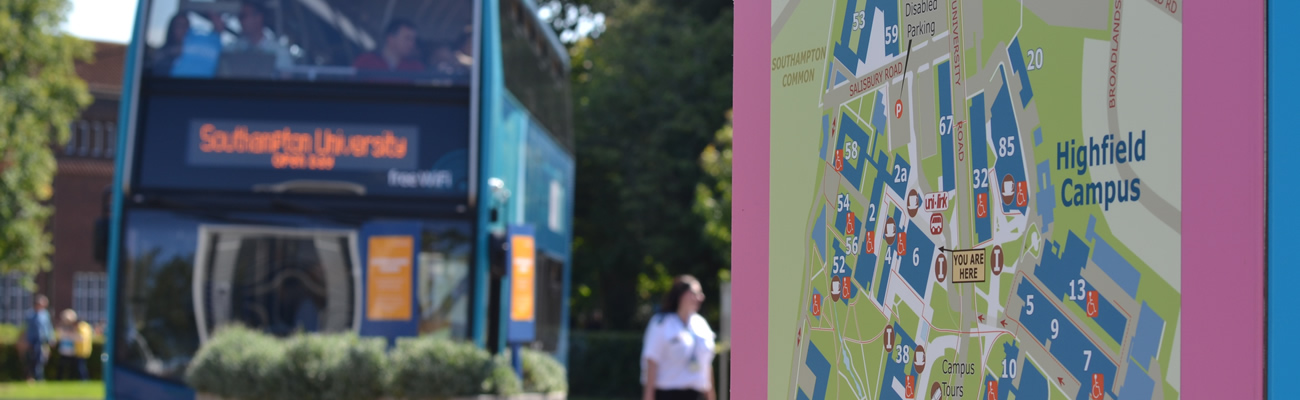An image of a UniLink bus out of focus, close to a campus map. 
